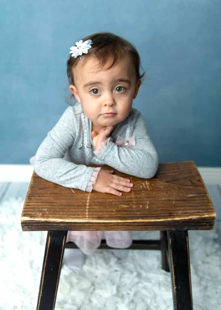 girl with hands on stool