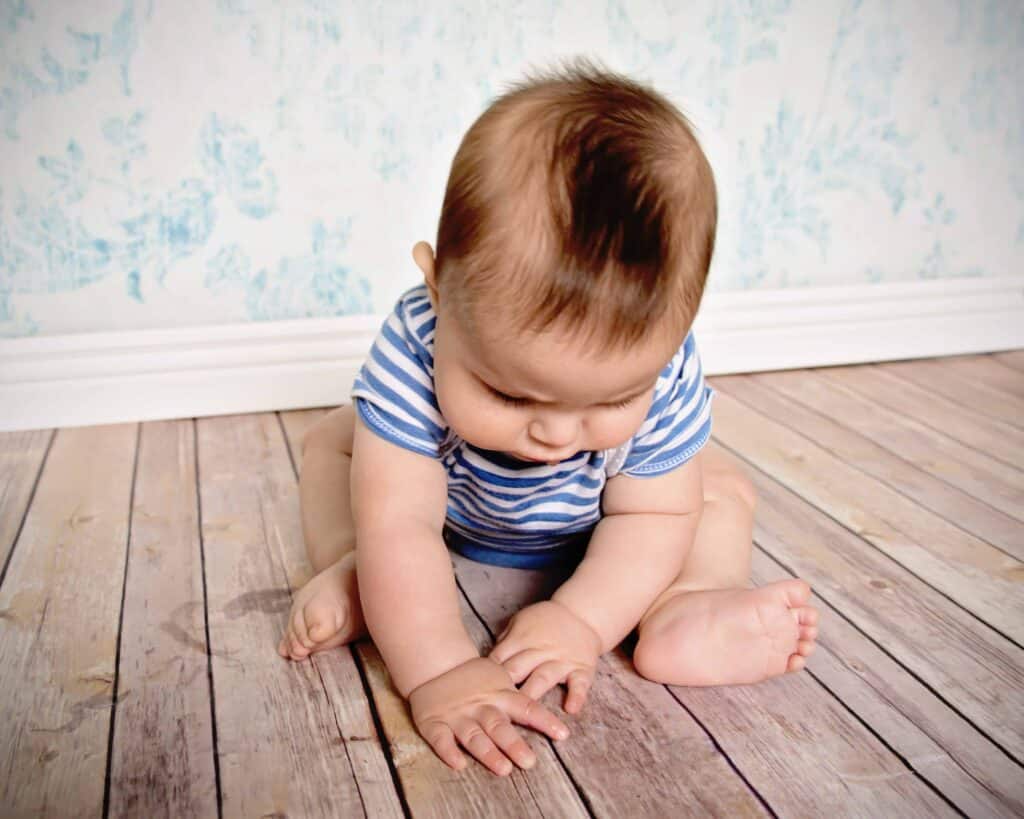 baby boy sitting looking at fingers