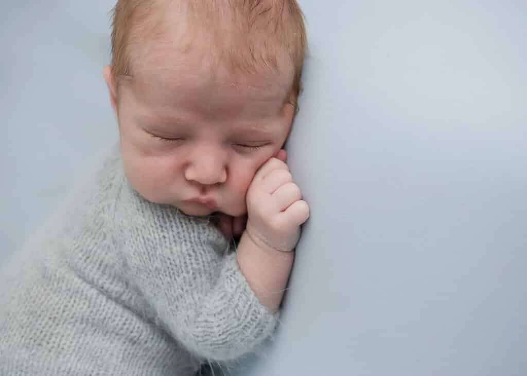 chubby newborn baby on baby blue blanket