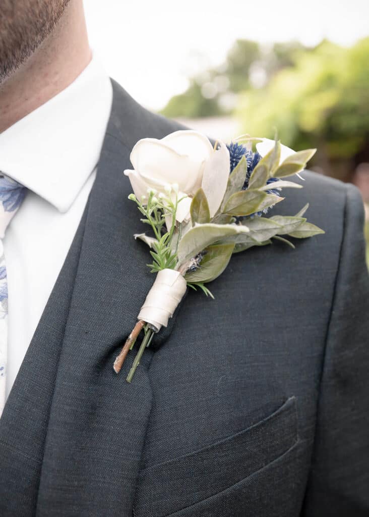 groom closeup florals