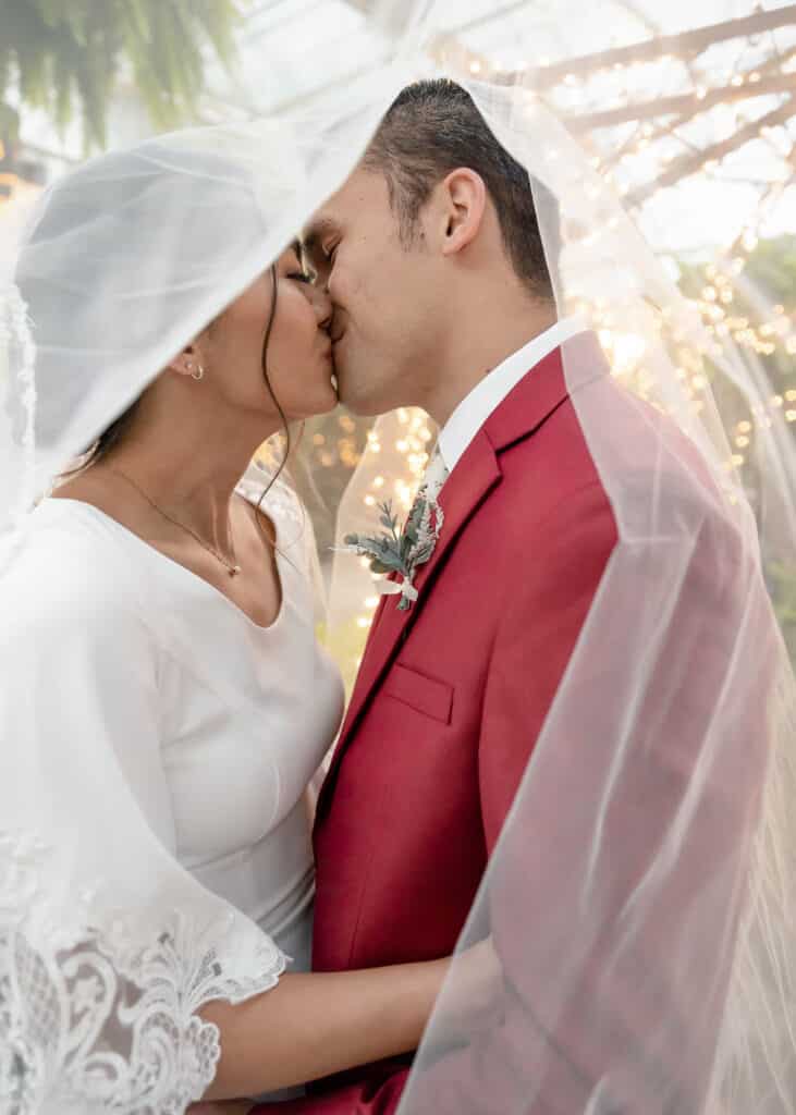 bride and groom kissing under veil