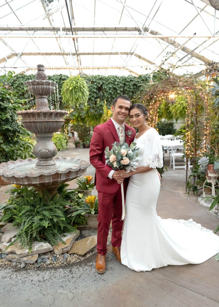 bride and groom in a greenhouse