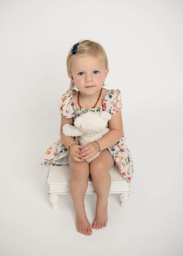 toddler holding white teddy bear