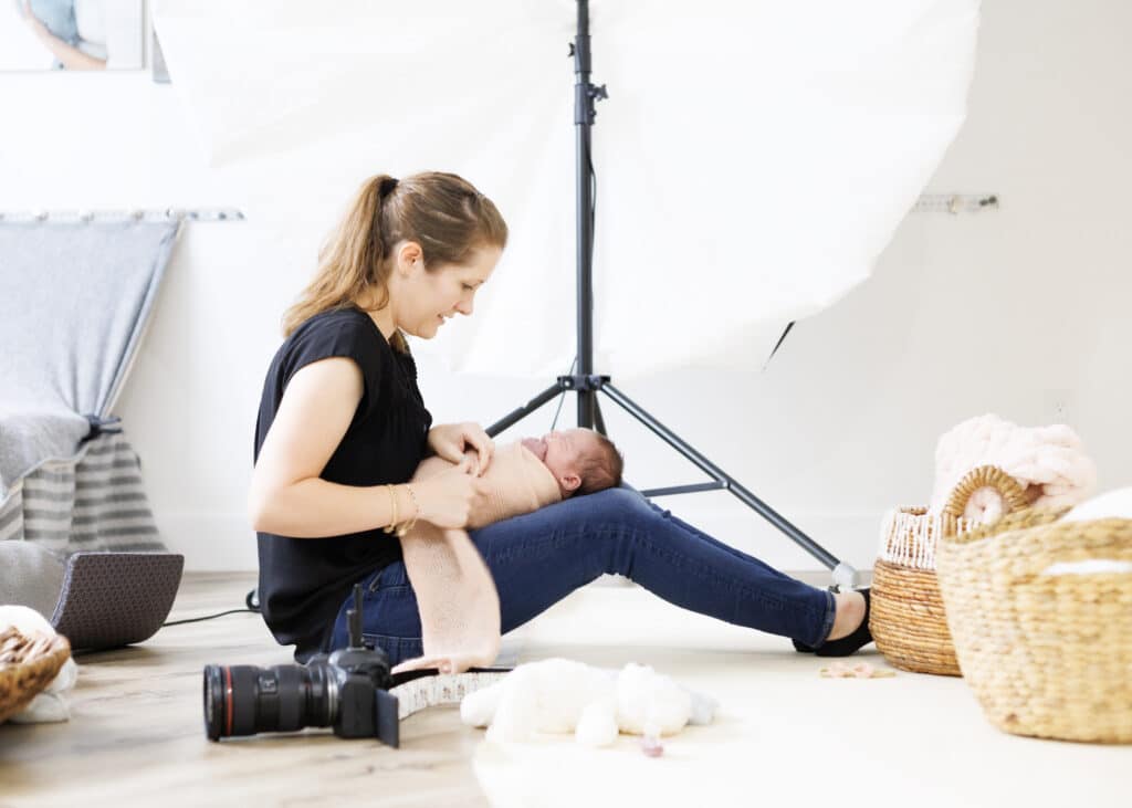 utah county newborn photographer wrapping a newborn baby in the studio for a portrait session