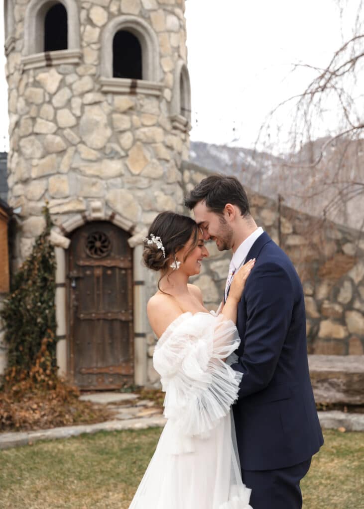 bride and groom in front of castle tower