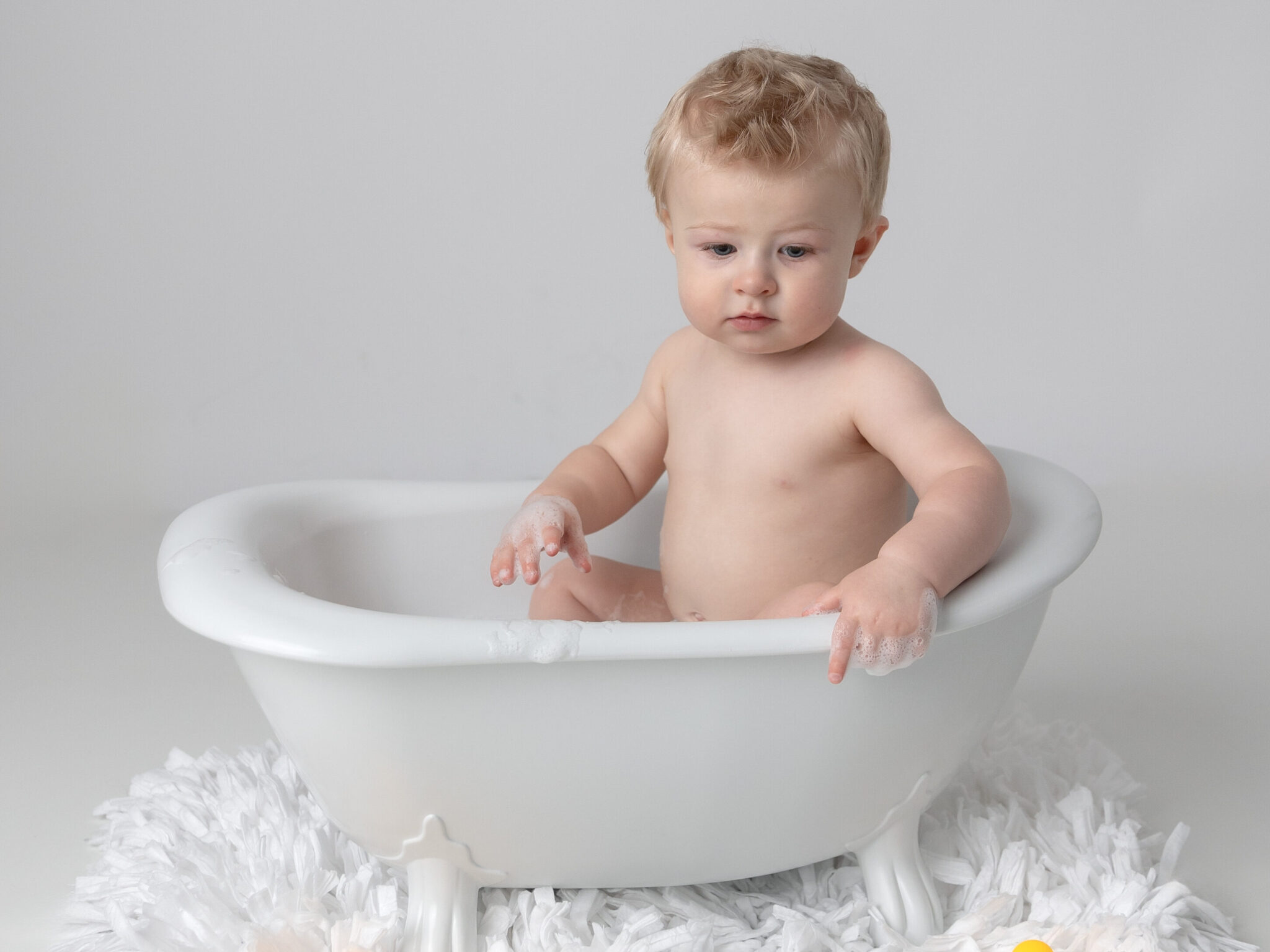 cleaning up from cake smash with a bubble bath in a splash session