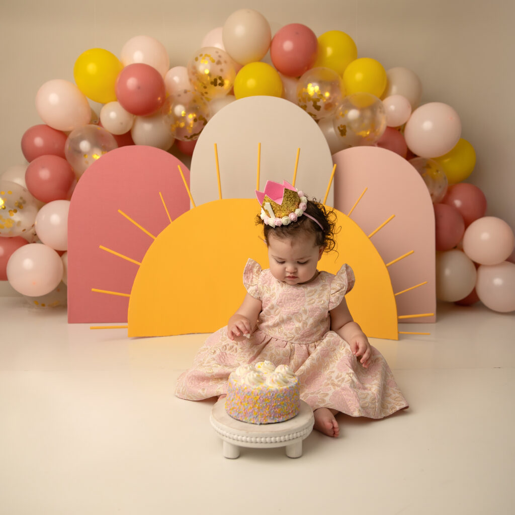 cake smash idea girls utah county baby looking down at cake