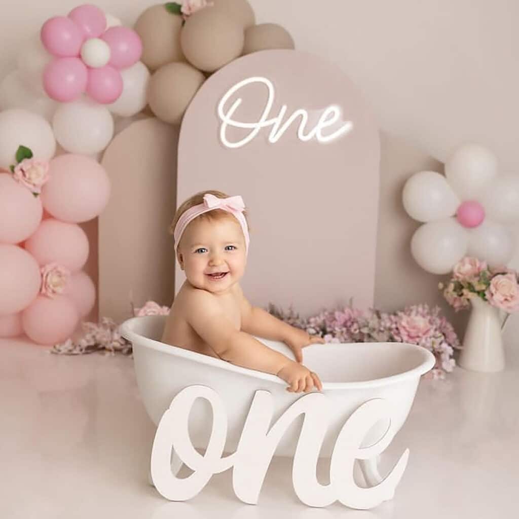 utah cake smash theme idea with neutral colored arches and pink balloons