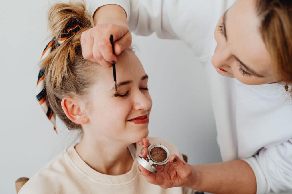 hmua putting makeup on woman