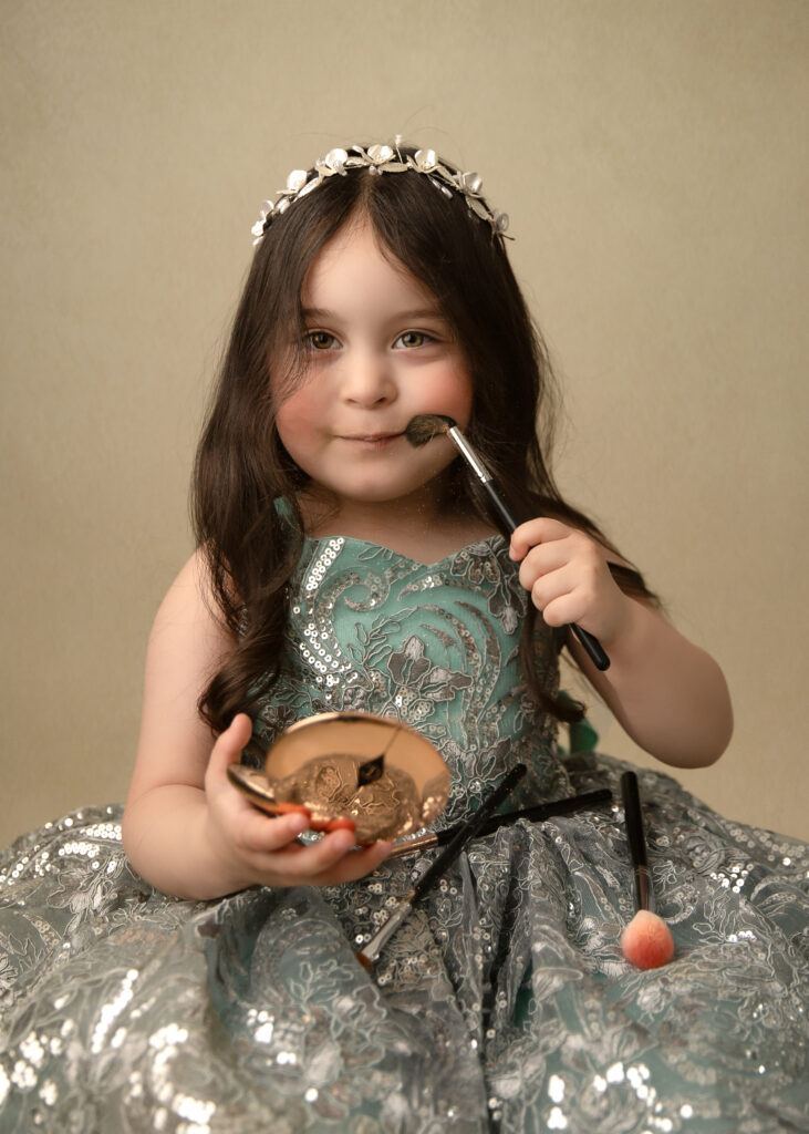 little princess doing makeup during a princess photography sessions